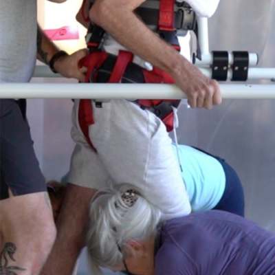 a photo of a physiotherapist working with a client on a body weight support treadmill